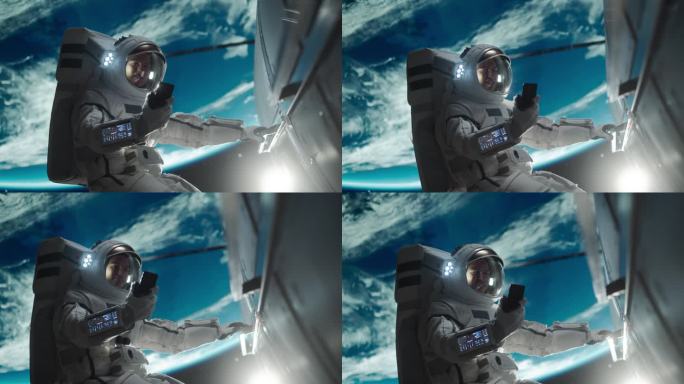 一个穿着太空服的人在外太空一边抓着卫星一边随意地打电话。宇航员通过智能手机上的视频通话应用程序与任务