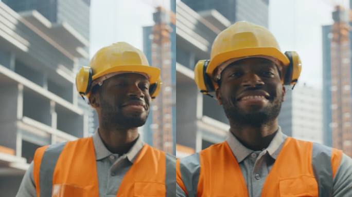 垂直屏幕:一个非洲建筑商的肖像，戴着安全帽和安全背心，在商业建筑工地摆姿势拍照和微笑。黑人交叉双臂