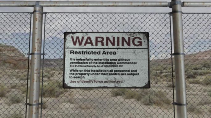 高质量的3D CGI渲染，在沙漠场景中，在一个高度安全的装置上，有一个警告禁区标志的链环围栏的平滑平