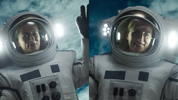 垂直屏幕:一名女宇航员漂浮在宇宙飞船外的肖像，背景是地球。女人对着镜头挥手。职业女宇航员穿着太空服，