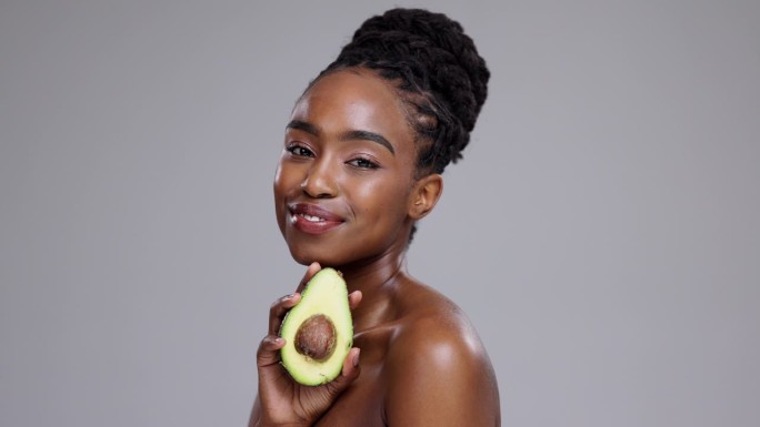 美容，牛油果和黑人女性的脸在工作室健康化妆品，营养和排毒灰色背景。肖像，快乐模型或水果可持续效益，环