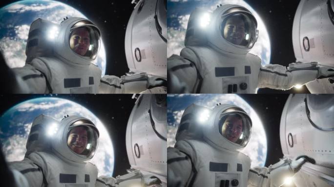一名身着太空服的男子手持卫星在外太空进行视频通话的POV自拍。宇航员通过手机应用程序与家人、朋友或同