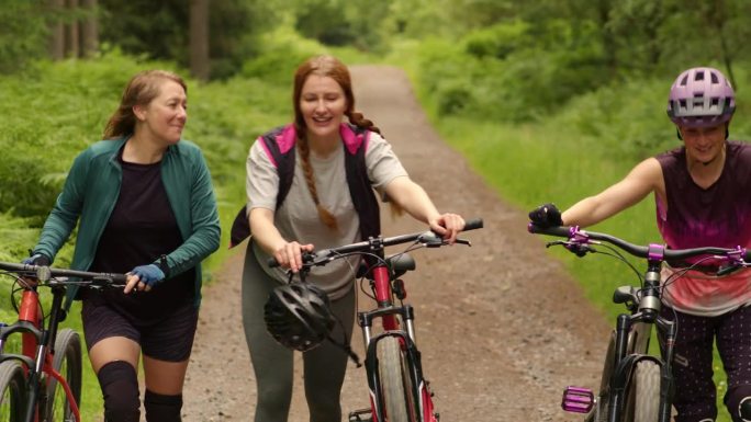 把自行车推向顶峰三个外国女人骑车登山运动
