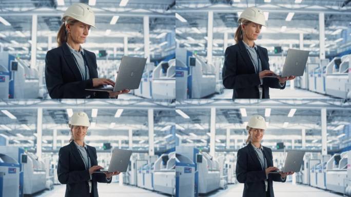 一位戴着白色安全帽的白人女性工业工程师站在电子制造工厂的笔记本电脑前，满脸笑容。成功的员工看着镜头。
