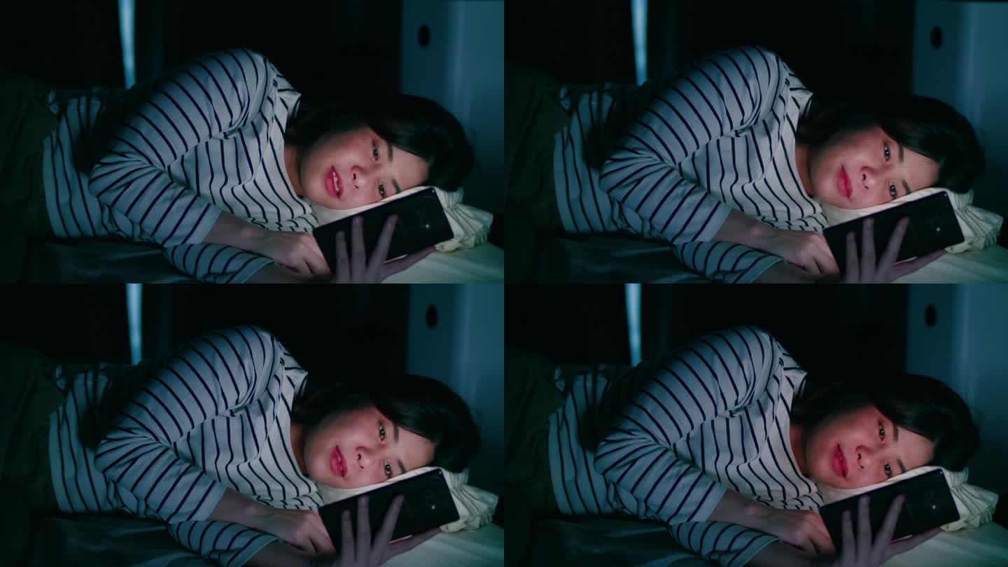 晚上躺在床上玩手机的女人