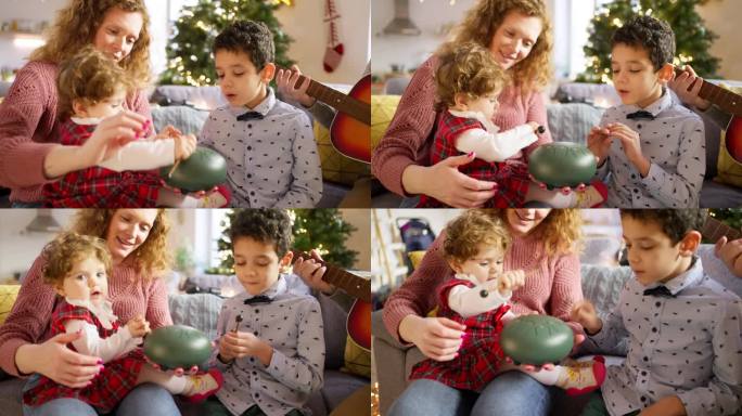 哥哥和姐姐在圣诞节和父母一起玩舌鼓