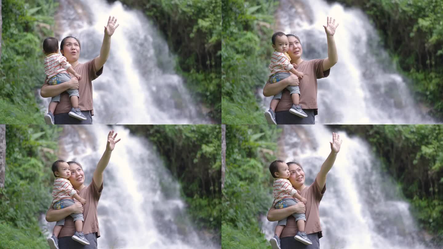 母亲带着儿子到瀑布外与大自然学习