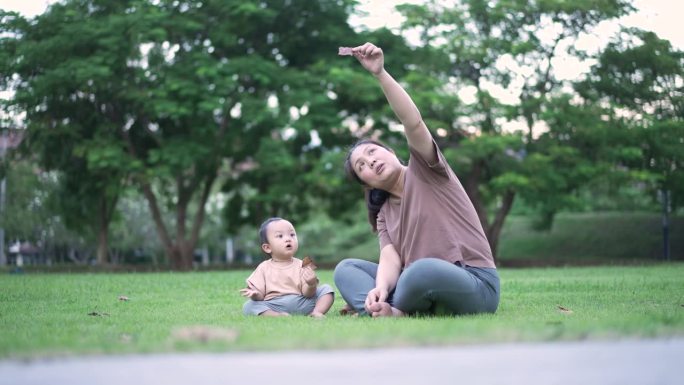 母亲带着男婴在公园户外玩耍