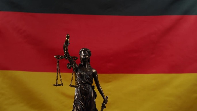 正义女神的铜像在德国国旗的背景下旋转。