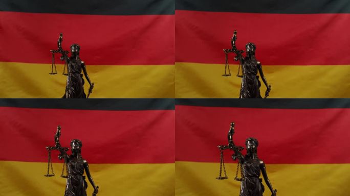正义女神的铜像在德国国旗的背景下旋转。