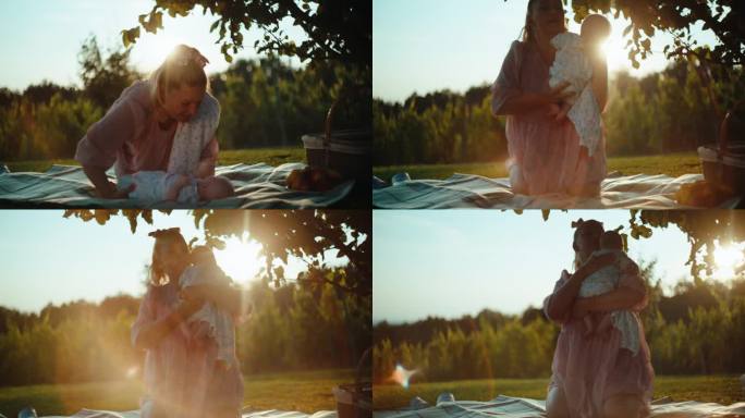 阳光明媚的一天，母亲抱着男婴跪在公园的野餐毯上