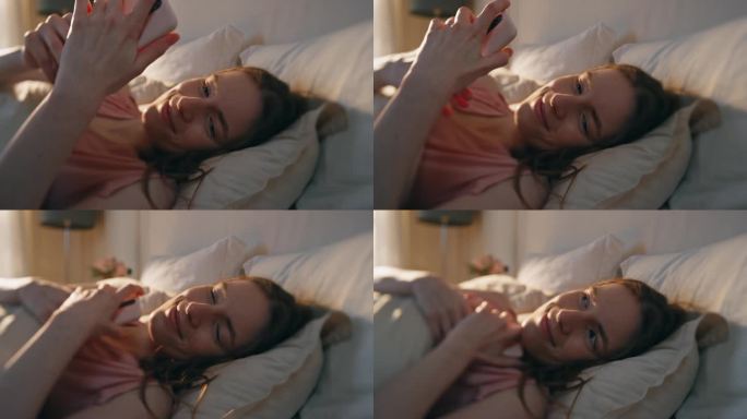 快乐女孩在床上看智能手机屏幕的特写。困倦的女人读留言