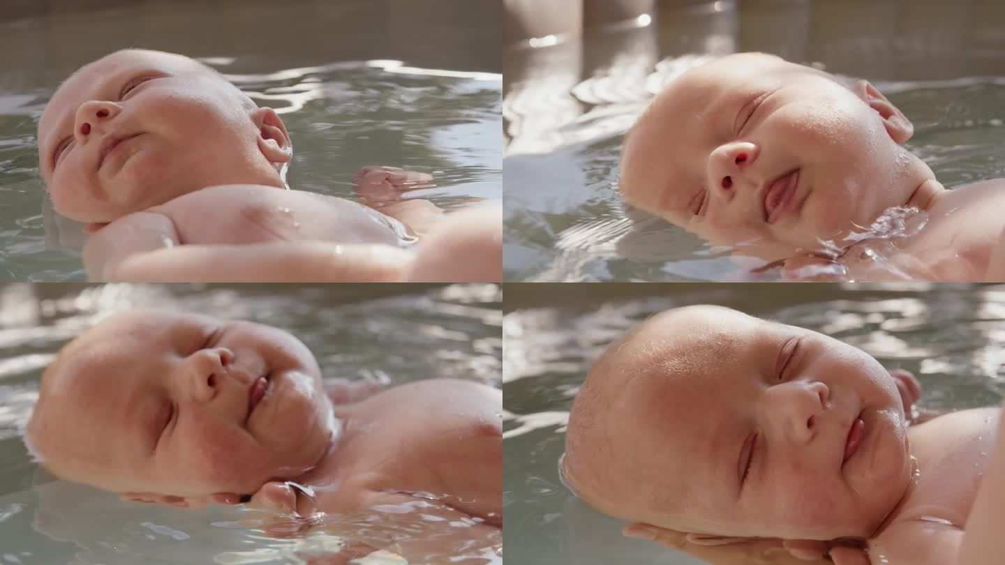 可爱的小男孩在浴缸里浮在水面上，妈妈的手在他的头下面