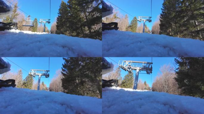 在通往山顶的升降椅上的滑雪板视角。