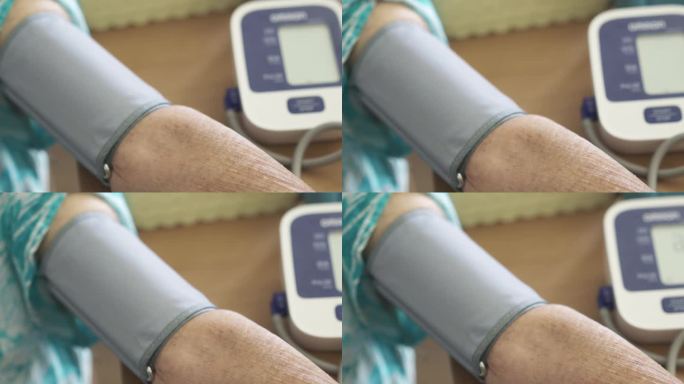 老年妇女使用血压监测仪