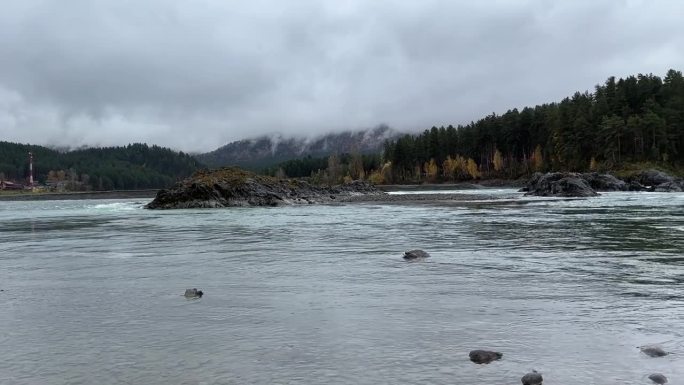 阿尔泰的风景，雾气笼罩着山林和卡顿河。前景有一些巨石。雨天