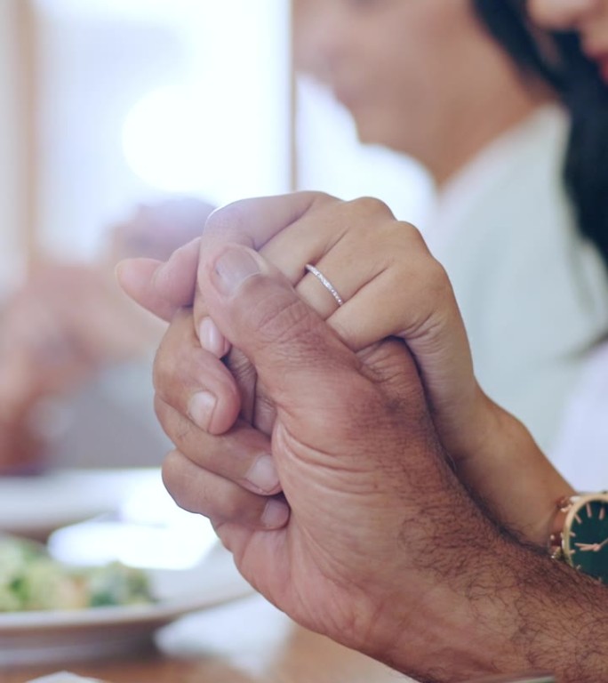 一家人，手牵着手，在家里用食物祈祷晚餐和庆祝，在餐厅里感激和感谢。团聚，父母和孩子用祈祷，信任和崇拜