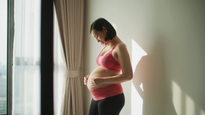 年轻女子在家和她的肚子亲密无间