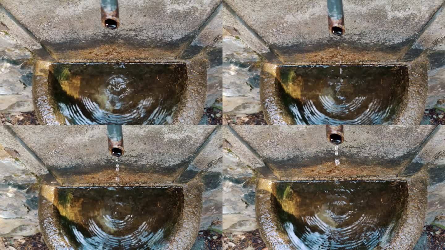 来自金属水龙头的泉水。特写镜头。前视图。在欧洲的森林里流淌着饮用水。