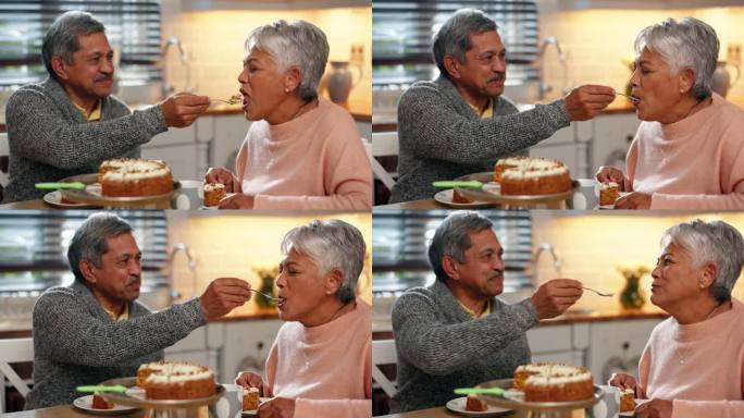 爱情，蛋糕和老两口在厨房一起吃茶点，在家里团聚。快乐，浪漫，退休老人在家里的餐桌上给他的妻子吃甜点。