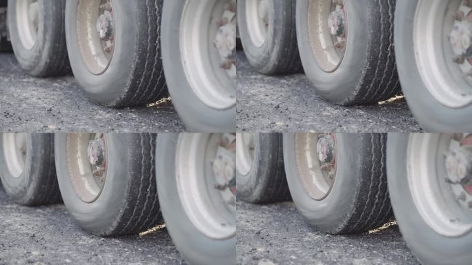 倒车的半挂车缓慢旋转的轮胎将卡车停在沥青停车场上