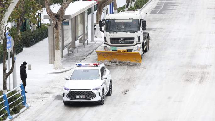 警车带着除雪车除雪