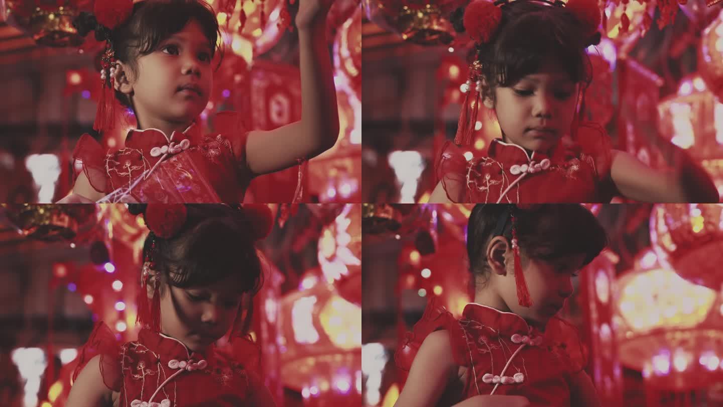 可爱的小女孩穿着中国服装看红灯笼