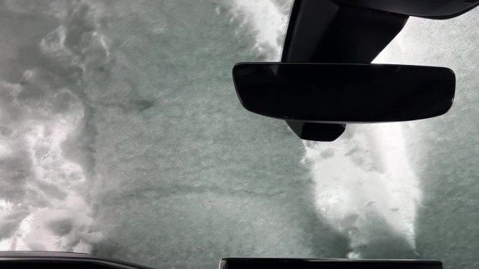 一名男子从车窗里清除积雪的内景