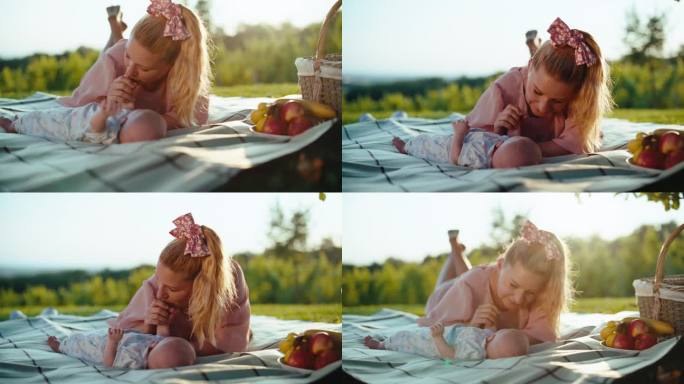 在阳光明媚的日子里，慈爱的母亲在公园野餐毯上与男婴一起度过闲暇时光