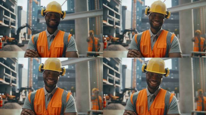 幸福成功的黑人建筑工人的肖像，双臂交叉站着，对着镜头摆姿势，微笑着。专业重工工程师，穿安全制服，戴安