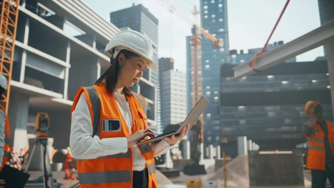 担任土木工程师的亚洲女建筑师。年轻的日本妇女使用计算机软件在城市中心规划、设计和建造一座商业房地产大