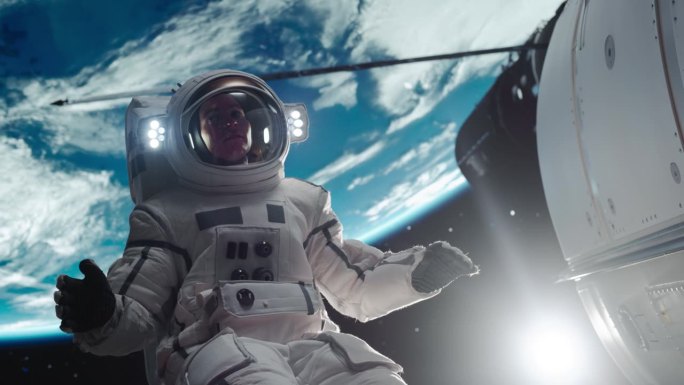 一个勇敢的宇航员漂浮在宇宙飞船外的肖像。在太空中工作的专业宇航员，在他的高级宇航服中为相机摆姿势，在