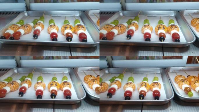 图为在韩国出售的塔古鲁糖浆糖衣水果橙色和亮麝香葡萄