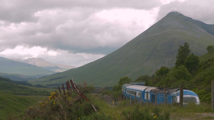令人惊叹的苏格兰风景，一列蓝色的旅客列车穿过曲线
