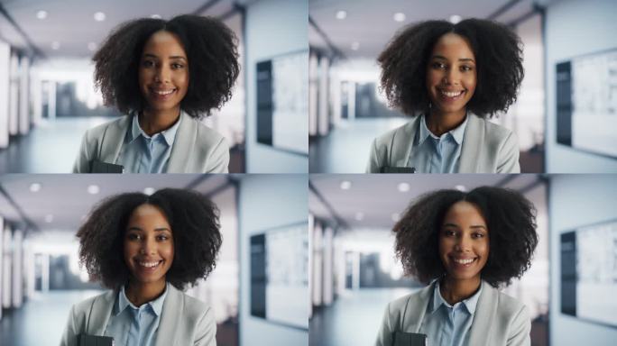 一个快乐时尚的黑人女孩的特写肖像，她留着非洲发型，穿鼻环，有纹身，在现代办公室的走廊里摆姿势。年轻漂