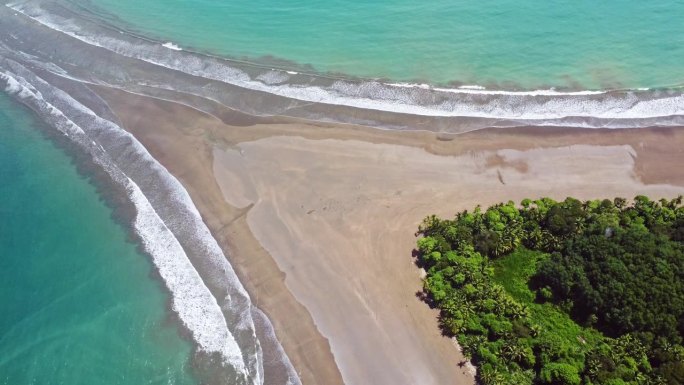 在哥斯达黎加的巴莱纳海洋国家公园，在蓝绿色海洋周围的鲸鱼尾沙形成和森林的空中多利