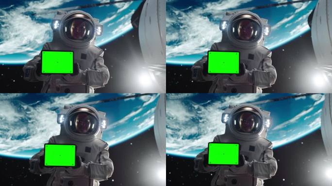 一个英俊的年轻宇航员手持平板电脑的肖像，绿色屏幕模板在水平位置。训练有素的专业人员穿着太空服为模拟广