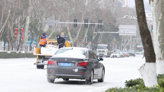 工作人员沿路抛洒融雪剂