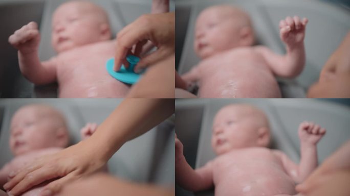 妈妈在家里的浴缸里给宝宝洗澡的小手
