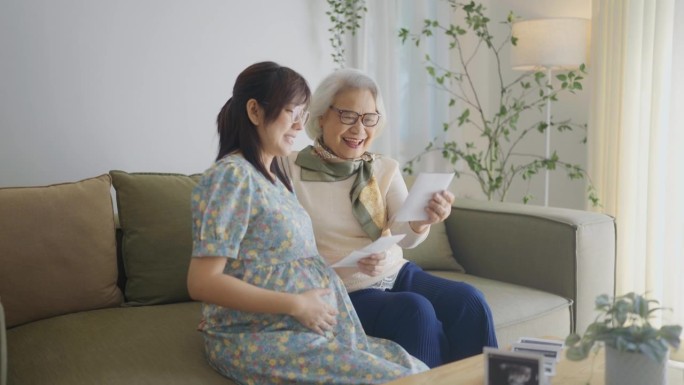 一位怀孕的母亲凝视着未出生婴儿的超声波扫描，他们的祖母在他们身边舒适的客厅里