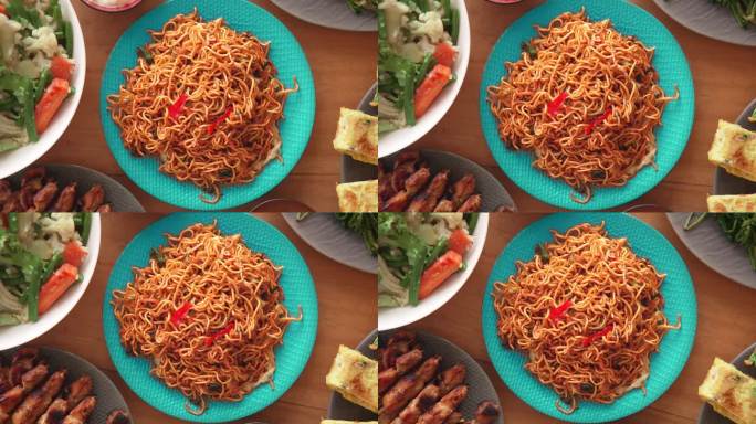 家庭餐桌上的新鲜亚洲美食特写。健康亚洲烹饪理念，东方产品烹饪。蔬菜沙拉和日式烤肉串上的炒面俯视图