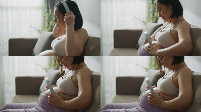 孕妇在家把耳机贴在肚子上
