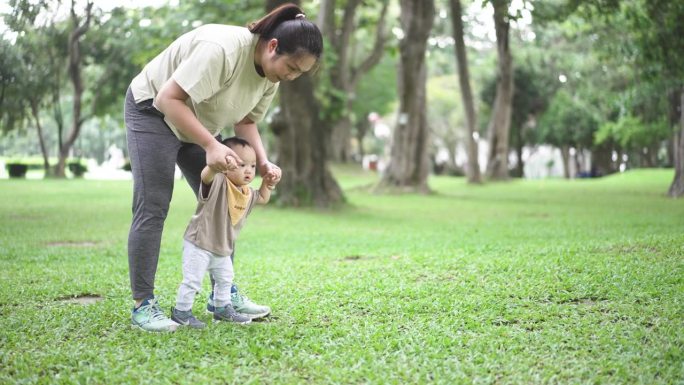 在妈妈的帮助下，男婴第一步训练