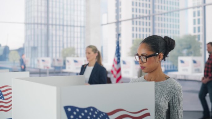 美国全国大选当天，一位年轻漂亮的黑人妇女在投票站旁填写选票。不同的男性和女性对当选官员的投票