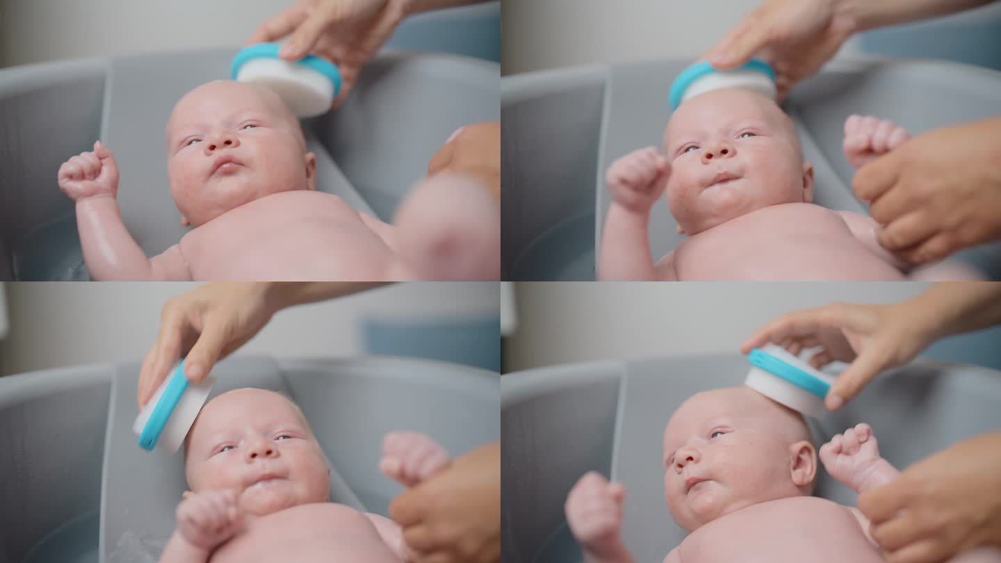 妈妈剪短的手在家里的浴缸里清洗男婴的头