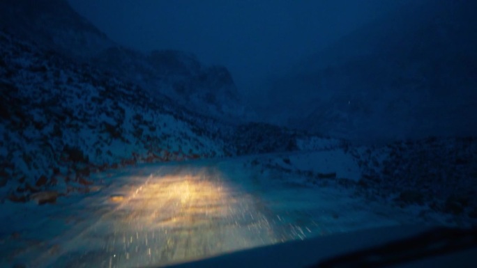 夜间的道路很可怕，山上有大雪。汽车在危险道路上行驶的镜头。冬季路况极端。夜间湿滑的雪地公路。冬天在山