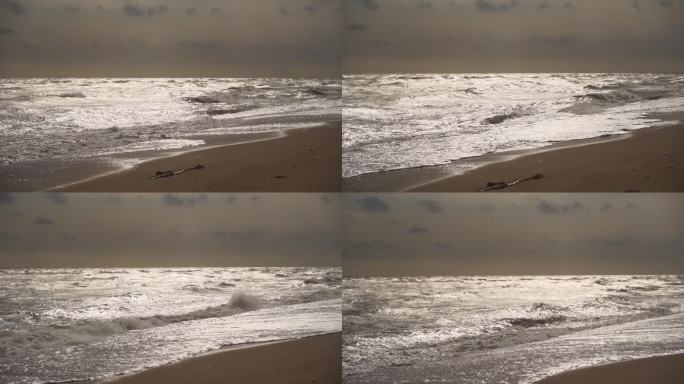 在暴风雨的天气里，大浪冲击着沙滩。乌云在头顶若隐若现，大海波涛汹涌。戏剧性的，自然的力量展示在海边。