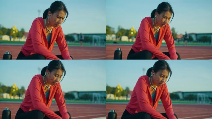 年轻的亚洲女运动员在户外跑步后，疲惫地戴着耳机听着音乐。健康的锻炼。