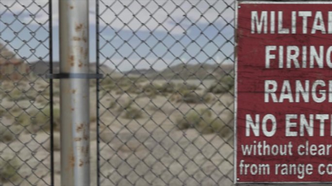 高质量的3D CGI渲染在一个高安全设施在沙漠场景中的链式围栏，与军事射击场禁止进入的标志