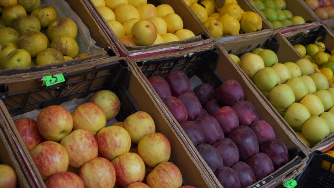 五颜六色的新鲜水果装在纸板箱里，摆在街边市场的柜台上